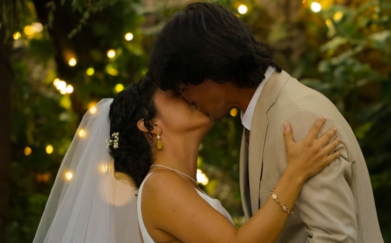 Close up of the bride and groom embracing in their first kiss.