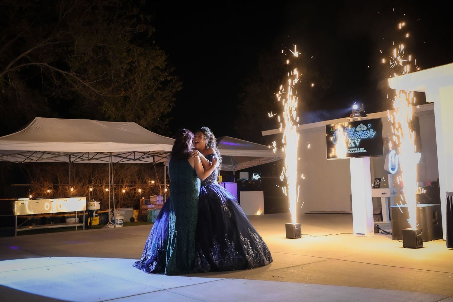 Mother daughter dance illuminated by spark machines with all guests seated surrounding them as they dance in the middle.