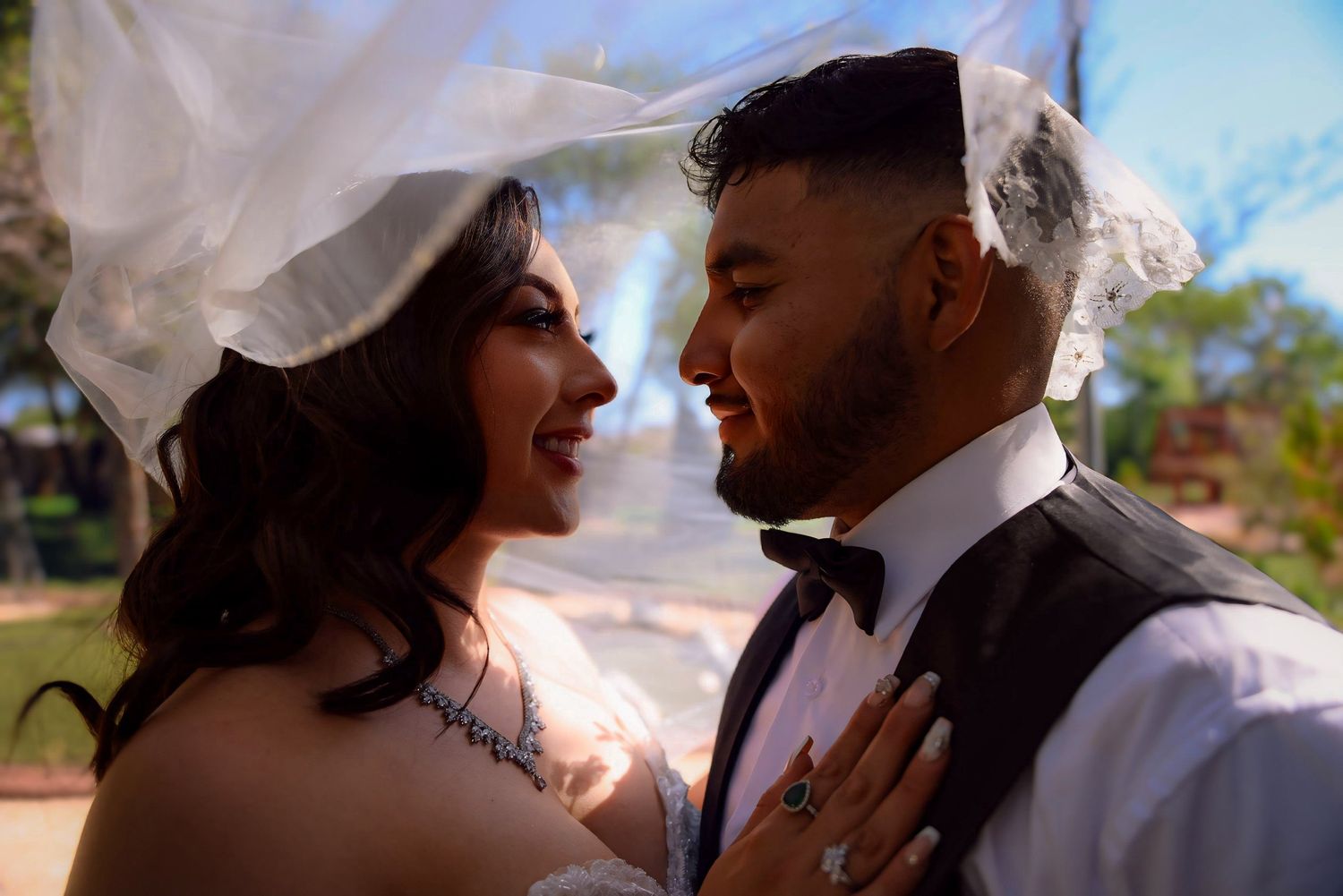 Newlywed couple looking into each others eyes lovingly.