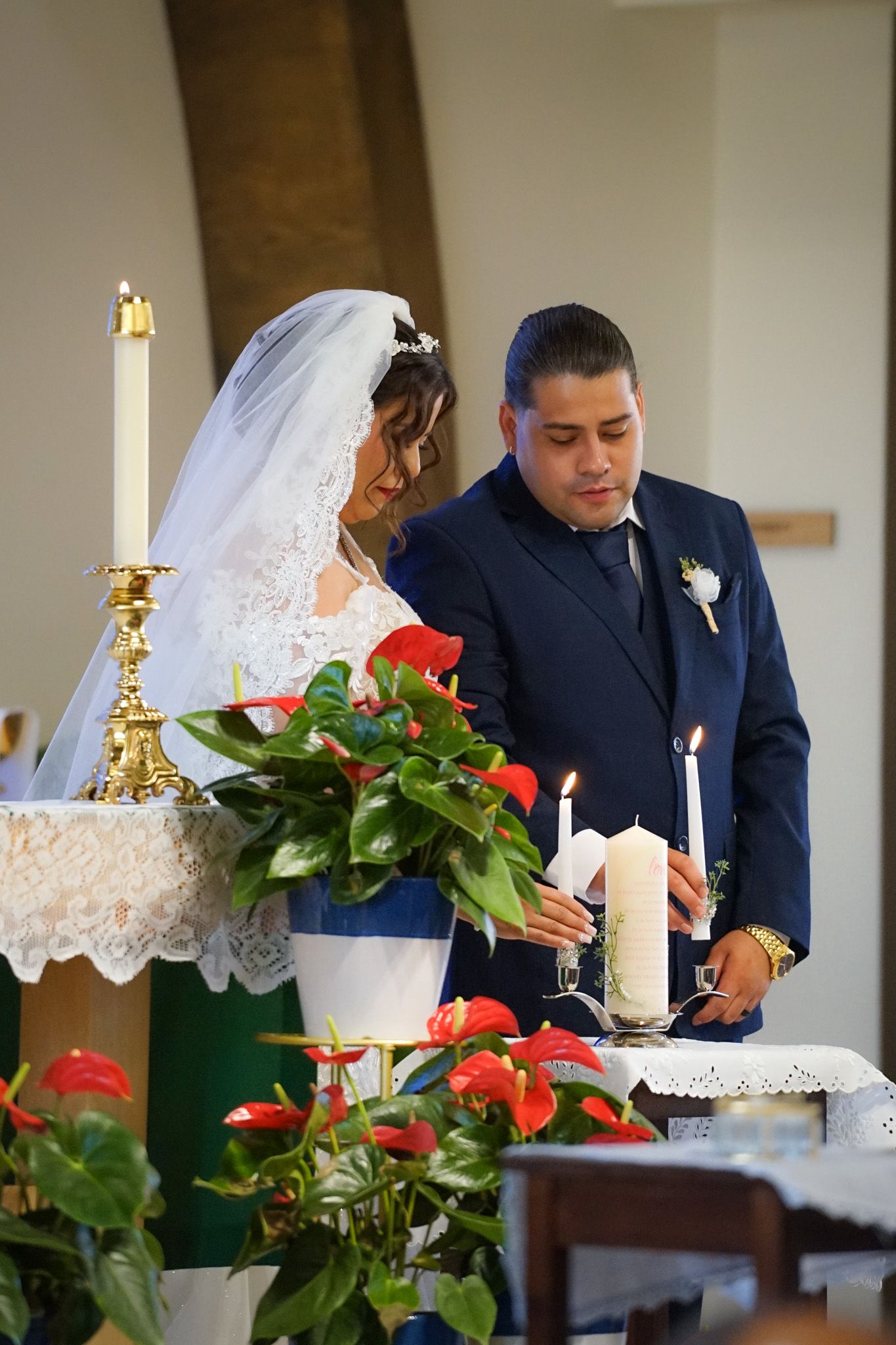 Bride and groom standing together inside the church during their wedding ceremony, smiling at the camera with the altar in the background