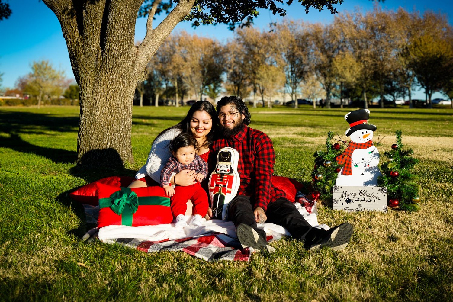 Family portrait of the 818 Films Photography owners laughing together outdoors at a park.