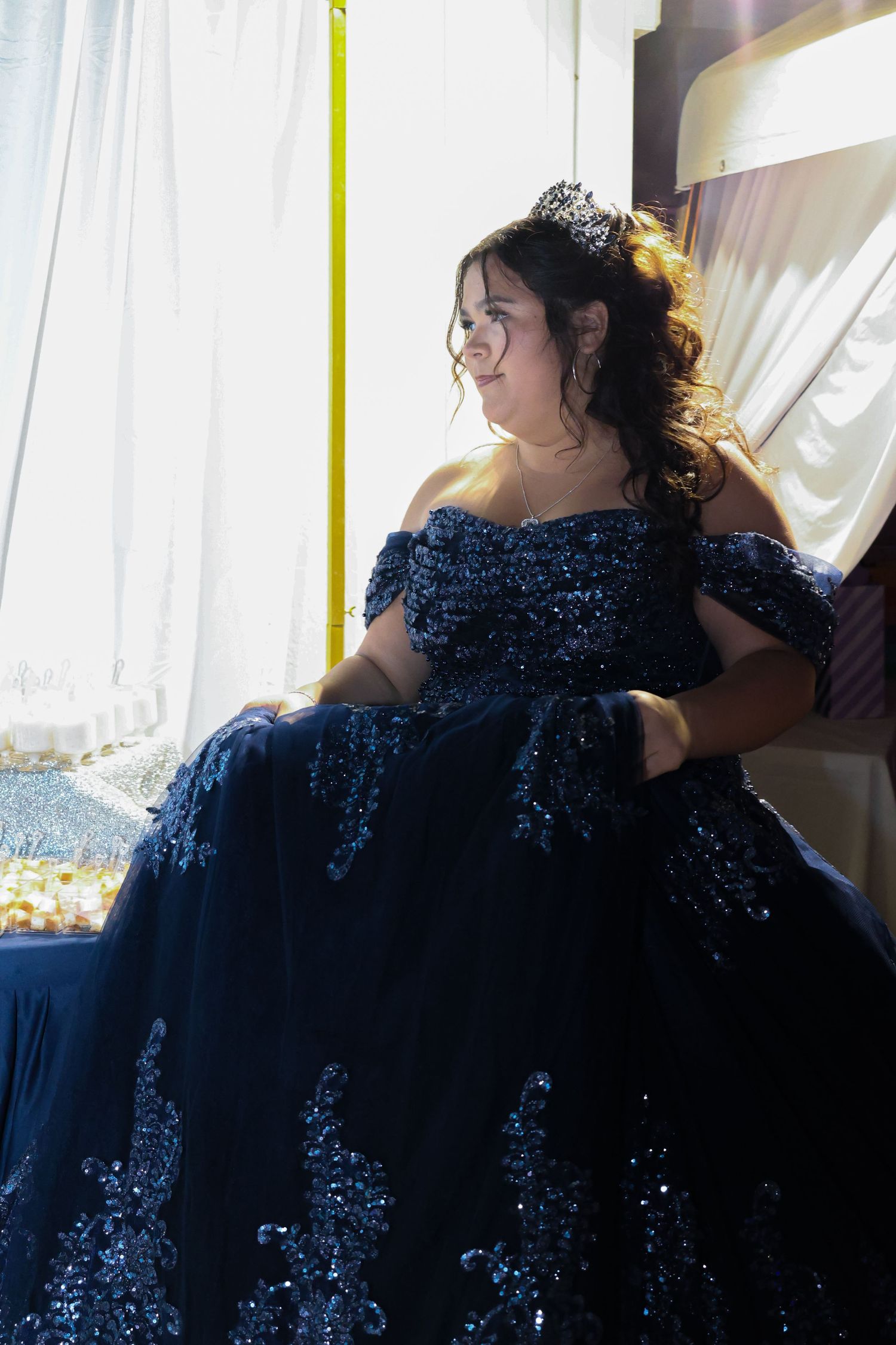 Side view of the quinceañera girl staring happily off in the distance.