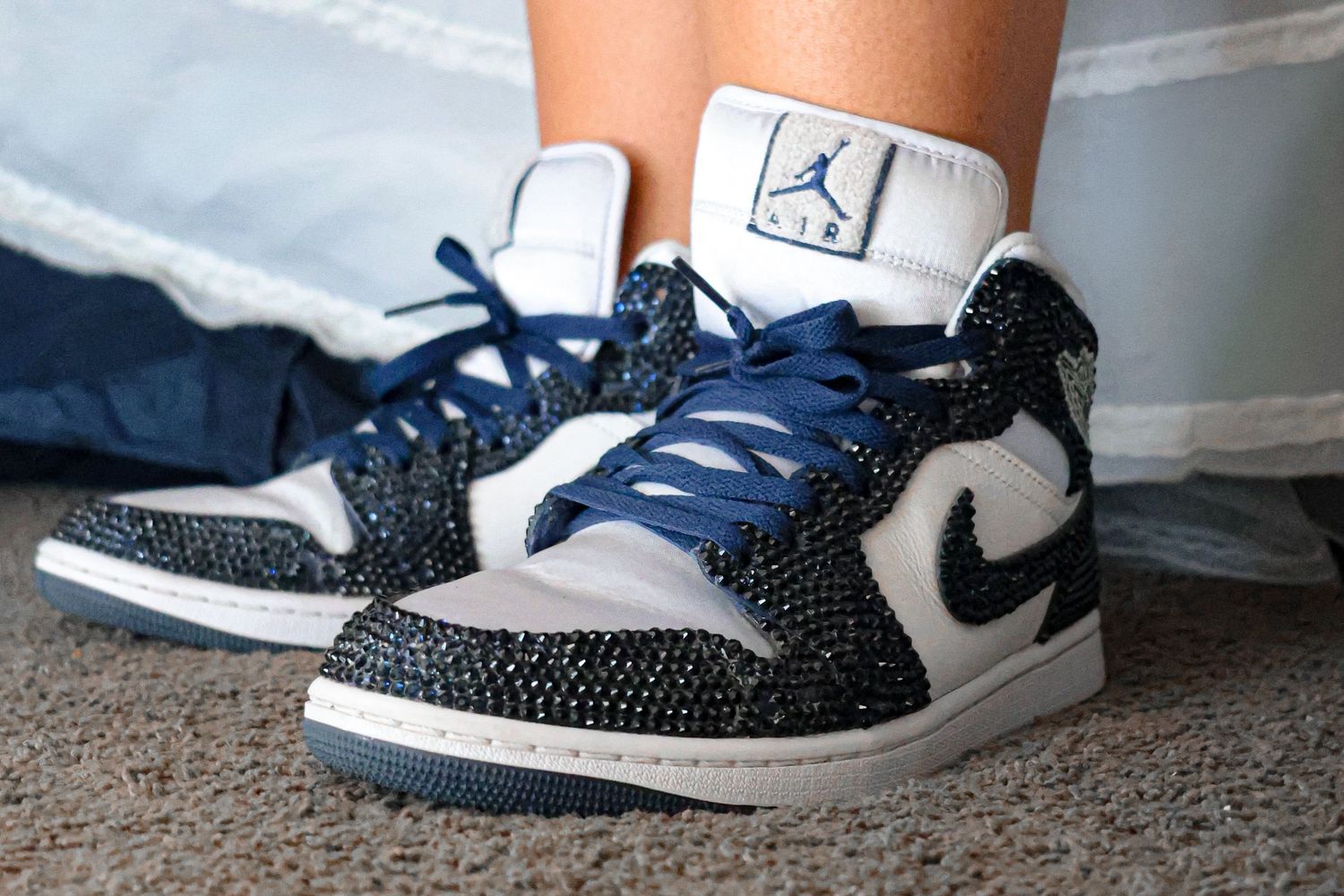 Close up of customized blue Nike Air Jordans that have been bedazzled to give the shoes a beautiful shine that dances in the light.