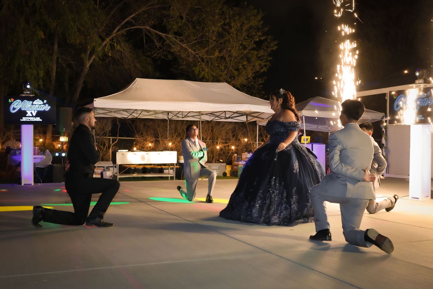 Surprise choreographed dance of the quinceañera court with the four chambelans on one knee with the birthday girl standing in the middle.