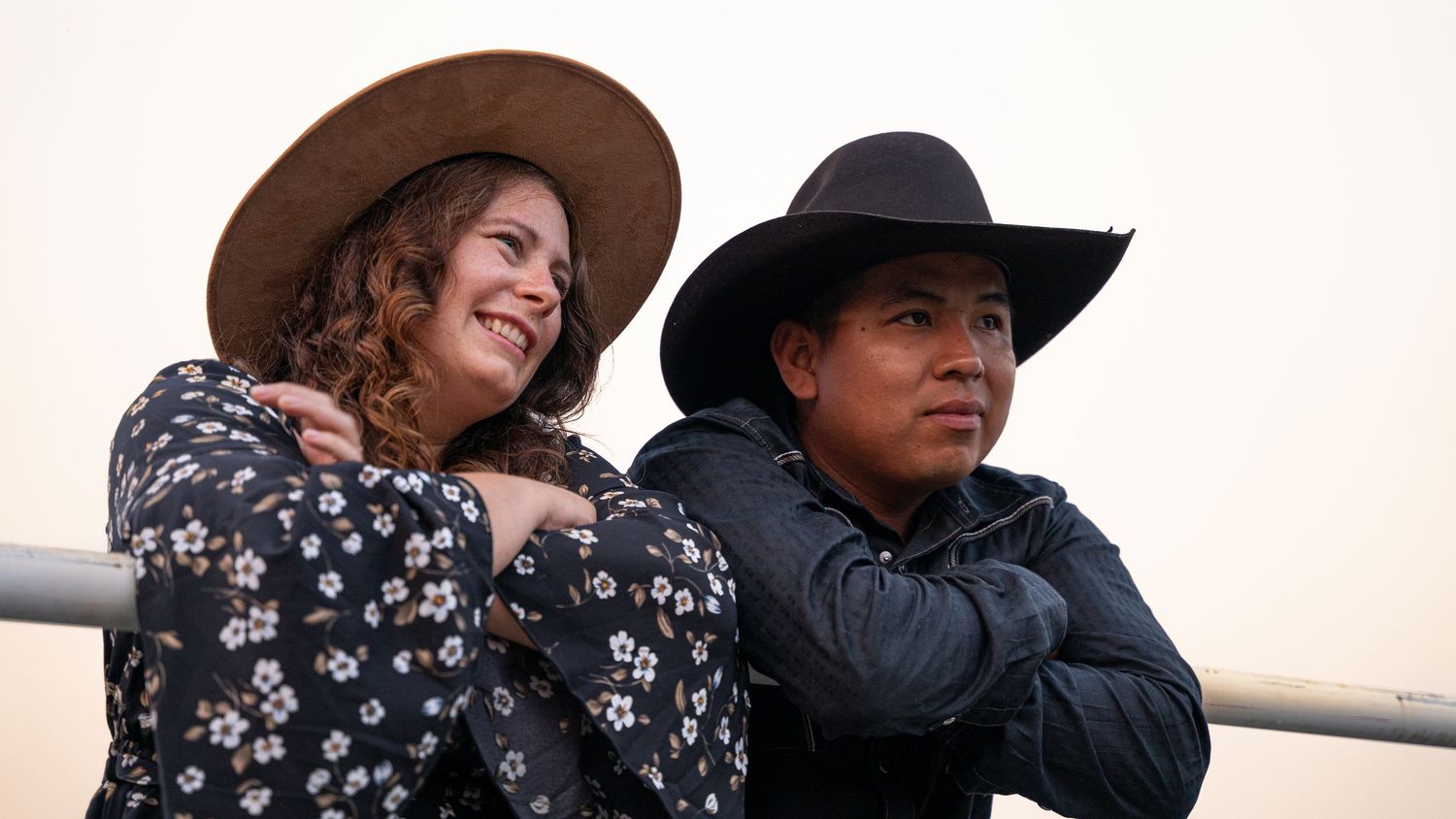 Group of friends enjoying an outdoor event with cowboy hats and casual attire.