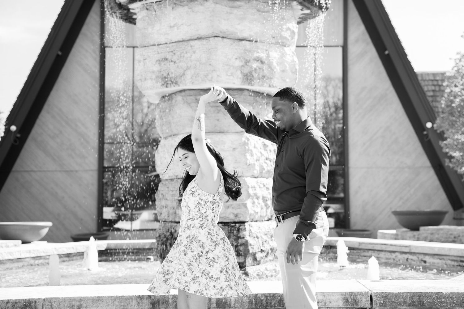 A couple dances and spins together in front of a tent structure.