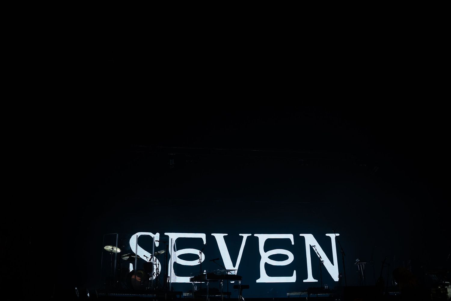 Dark background with illuminated text spelling out 'SEVEN'.
