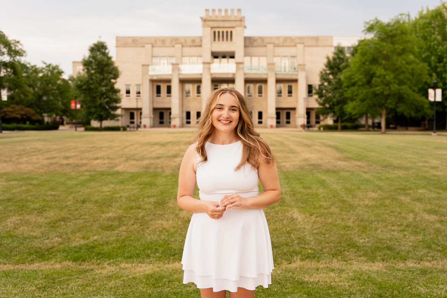 Outdoor portrait session in front of a grand stone building with grassy lawn.
