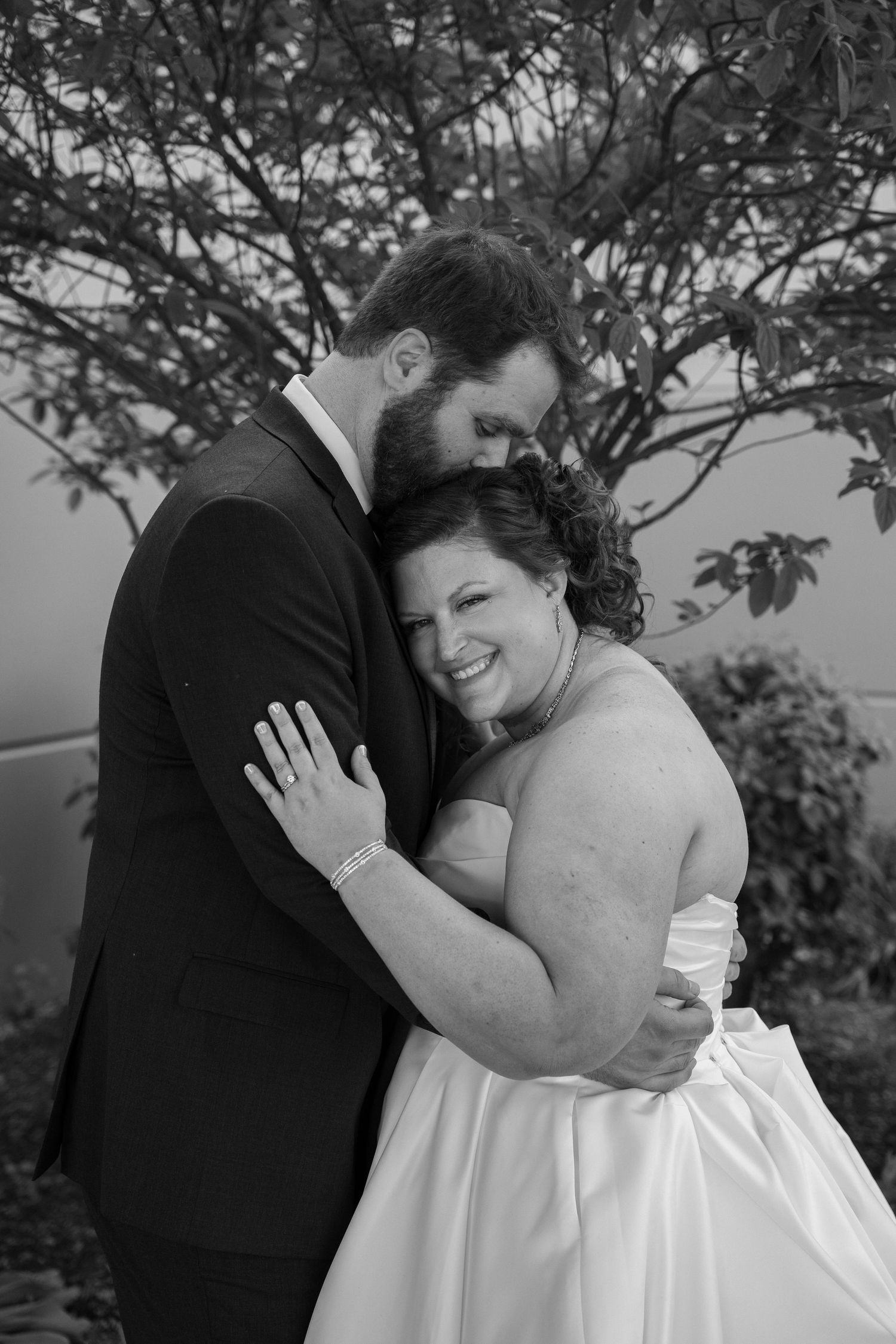 Black and white series of intimate wedding portraits taken outdoors with natural foliage.