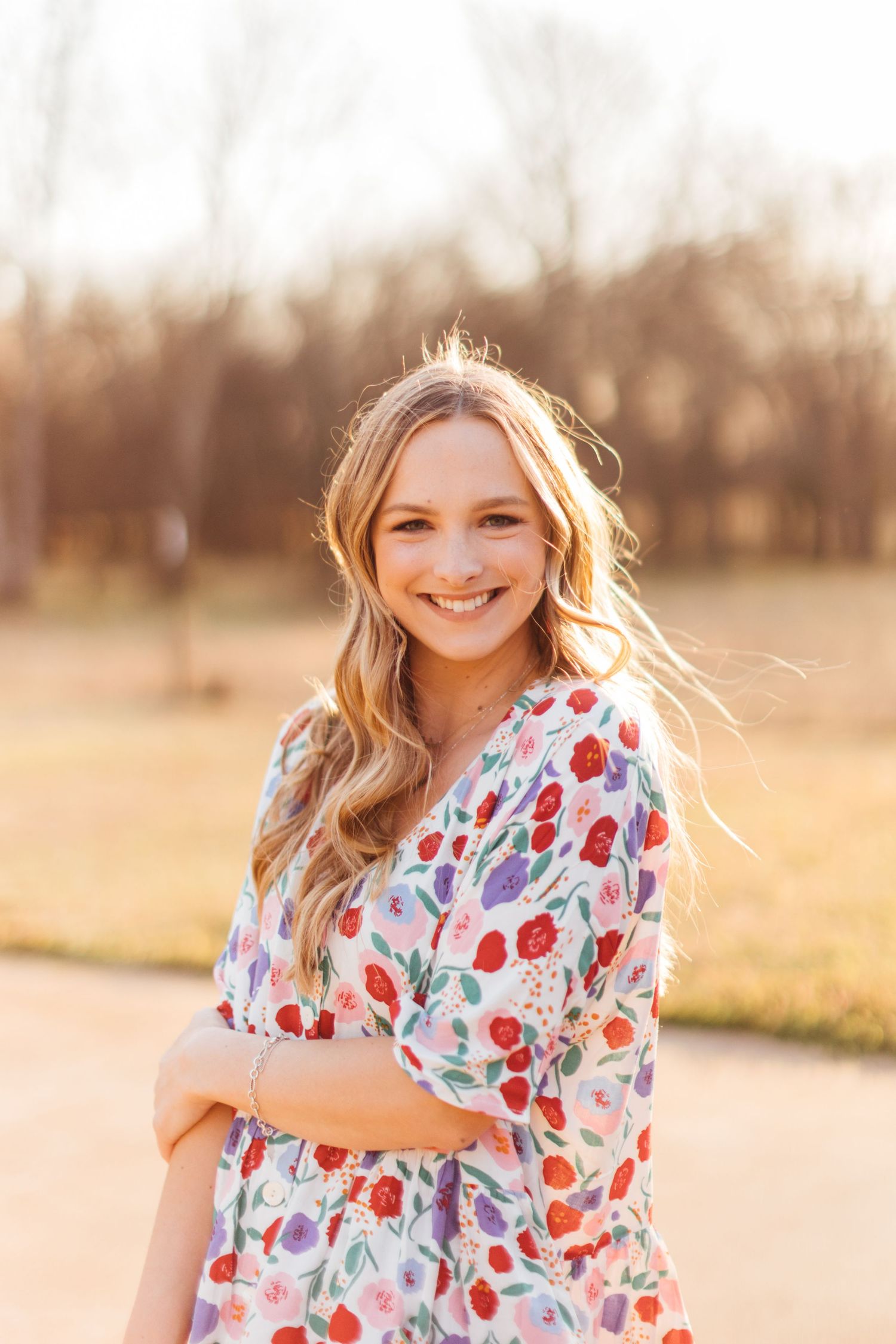 A floral dress is captured in a series of outdoor portraits during golden hour with warm sunlit backlighting.