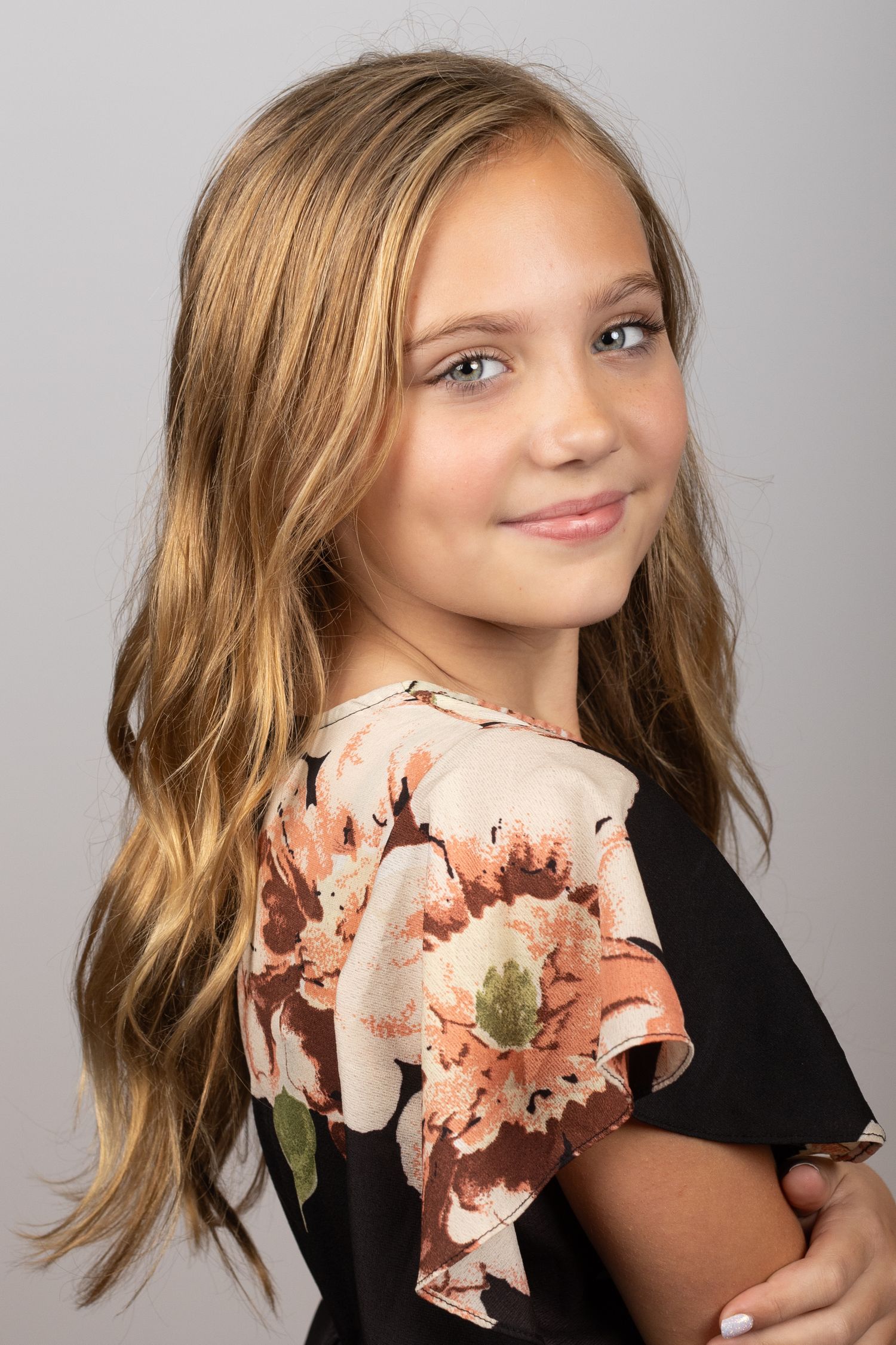 A series of profile portraits showing hair movement and a pink floral accessory against a gray background.