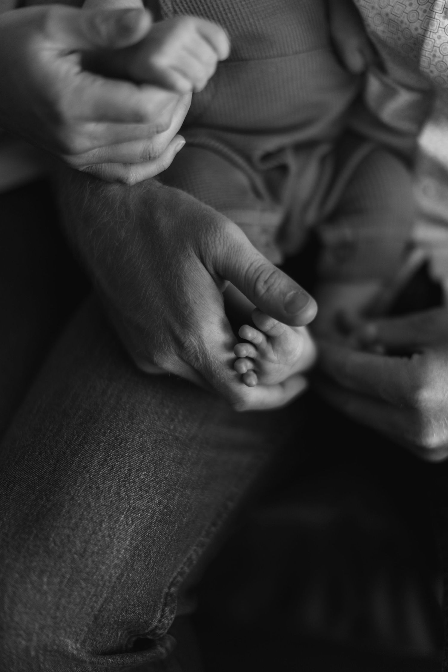 A series of black and white close-up shots showing hands holding and examining small objects in dim lighting.