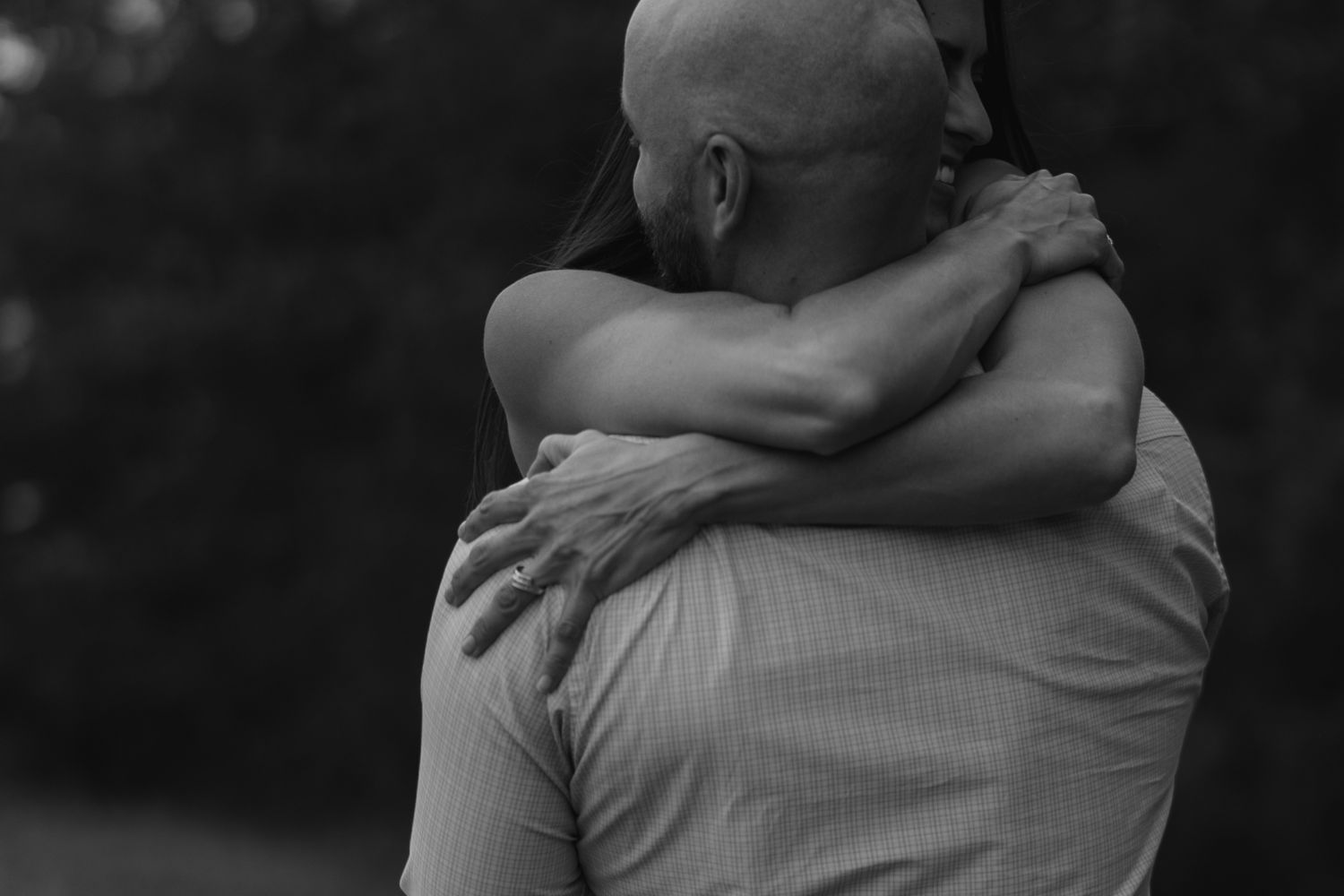 Black and white photograph showing a series of intimate embraces and hugs between people in a row.