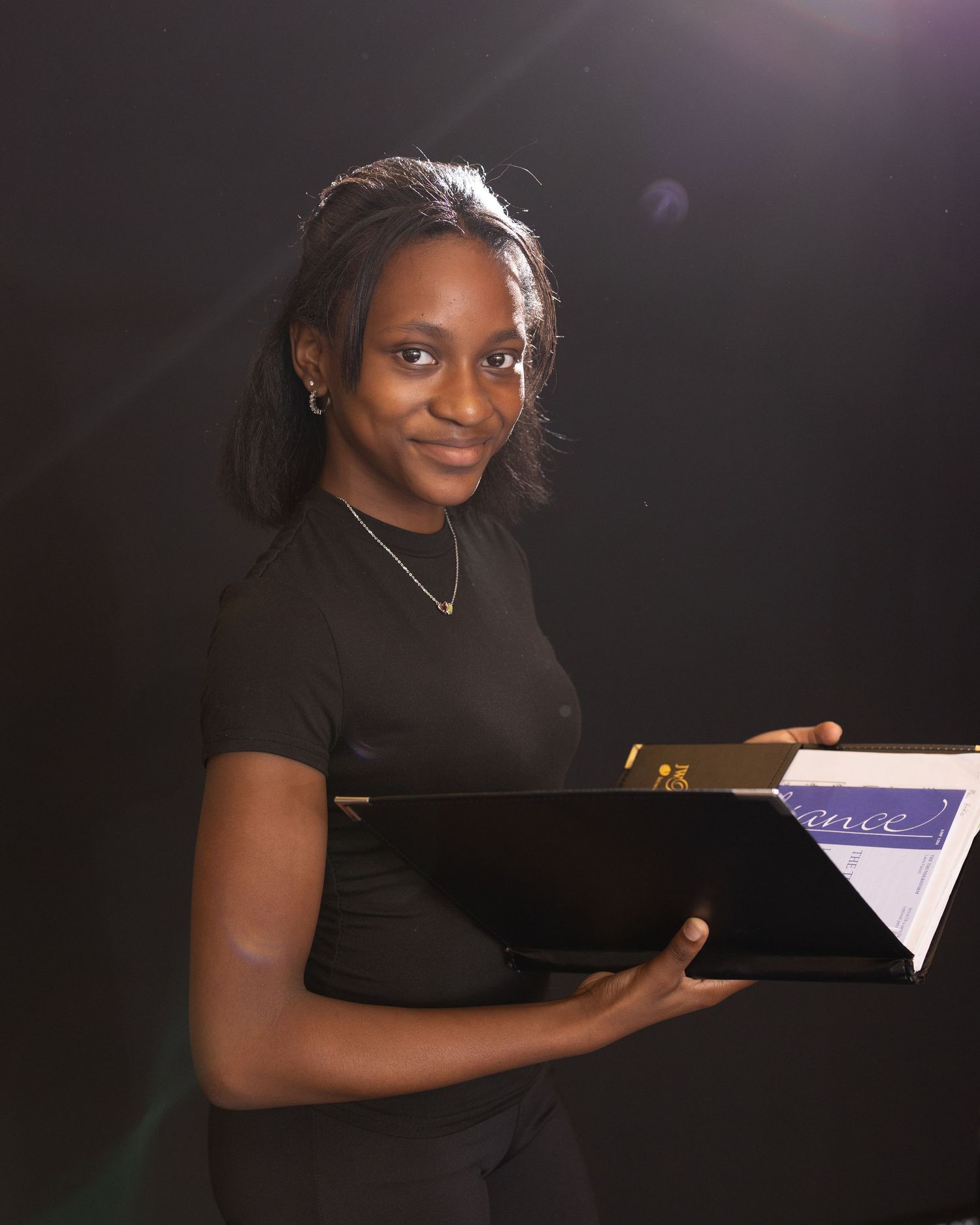 Professional studio portraits of a pianist in a black dress sitting at a grand piano against a dark background.