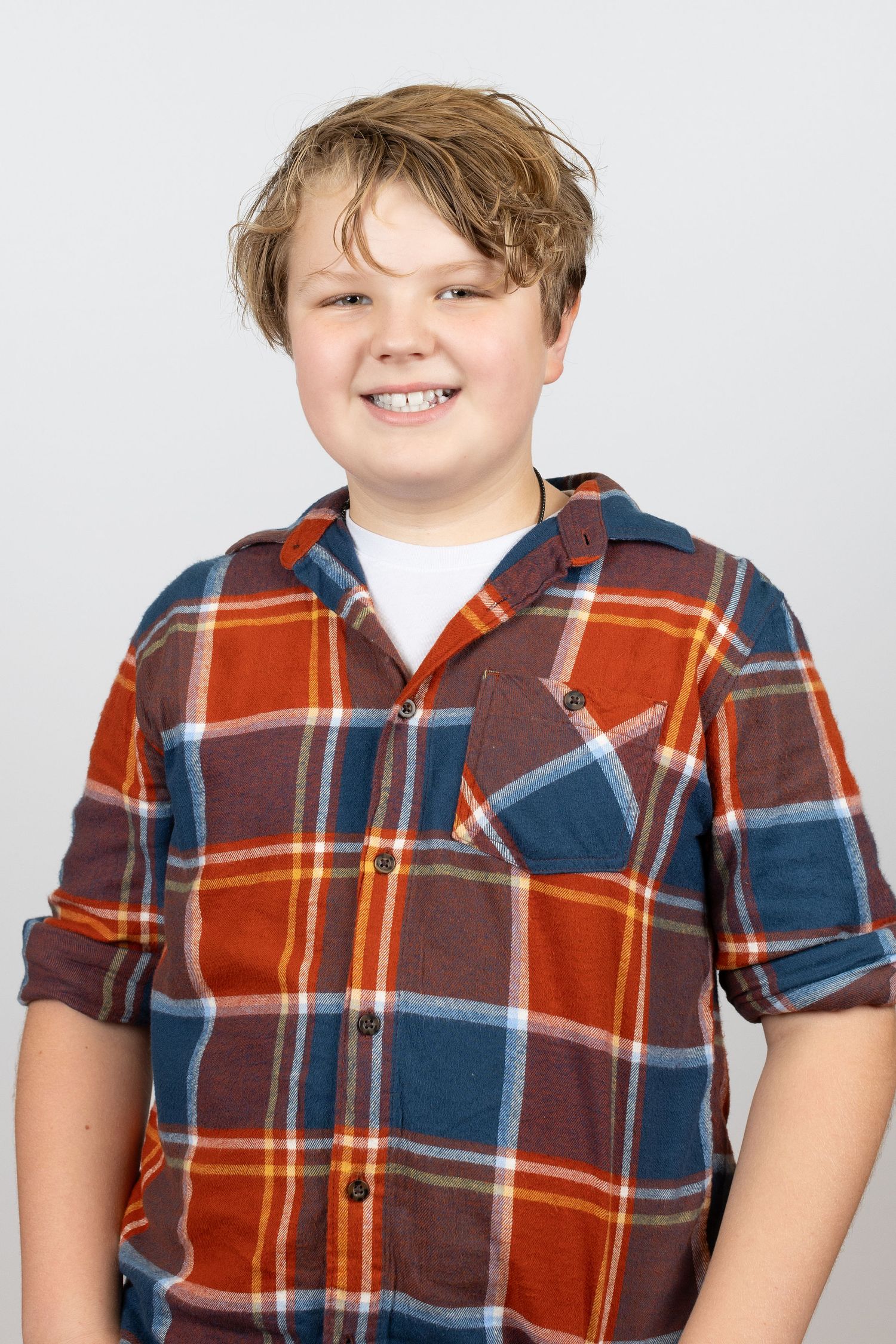 A series of headshots showing someone wearing a plaid button-up shirt in orange and blue tones against a light background.