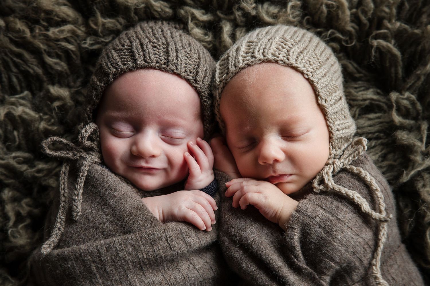 Sleeping twins in matching gray knit bonnets snuggled together. Cambridge Waikato NZ Photographer
