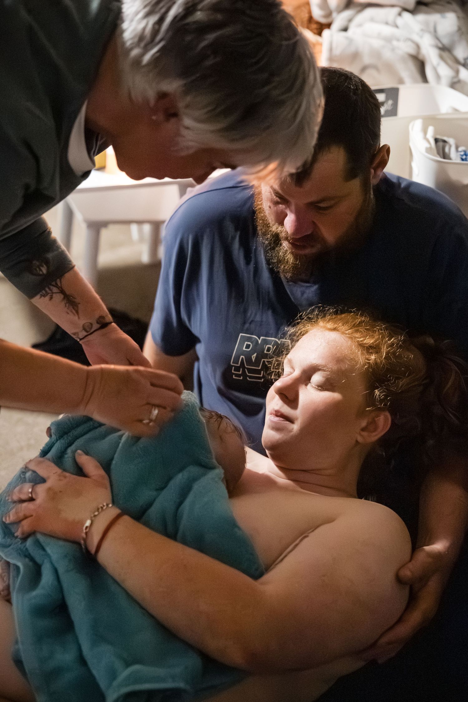 A series of intimate photographs showing tender moments between parent and child in a dimly lit setting.