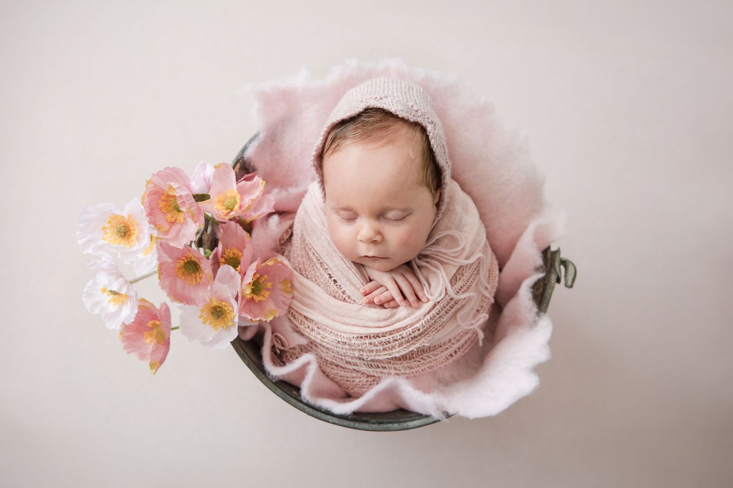 A collage of newborn baby photography featuring soft pink tones, floral elements, and delicate wrapping techniques.