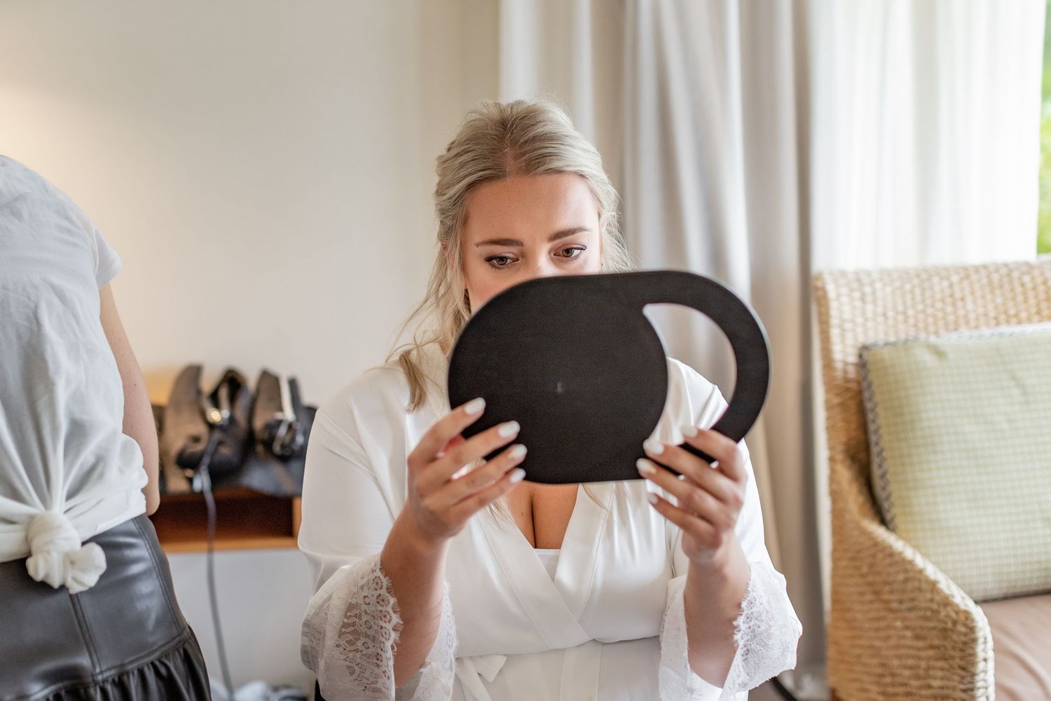 Four related lifestyle photos showing someone holding a dark tablet device while relaxing in a bright interior space.