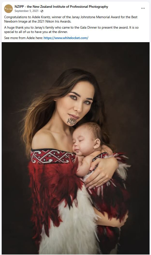 A tender portrait shows a mother and sleeping baby in traditional Maori dress with a red and black design against dark background.