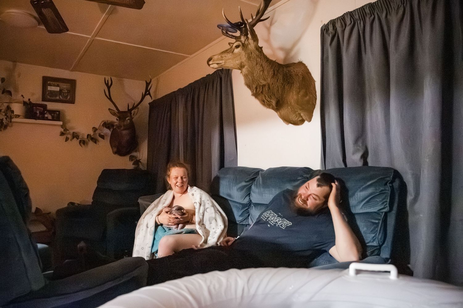 Interior view of a room with curtains and mounted deer antlers on the wall.