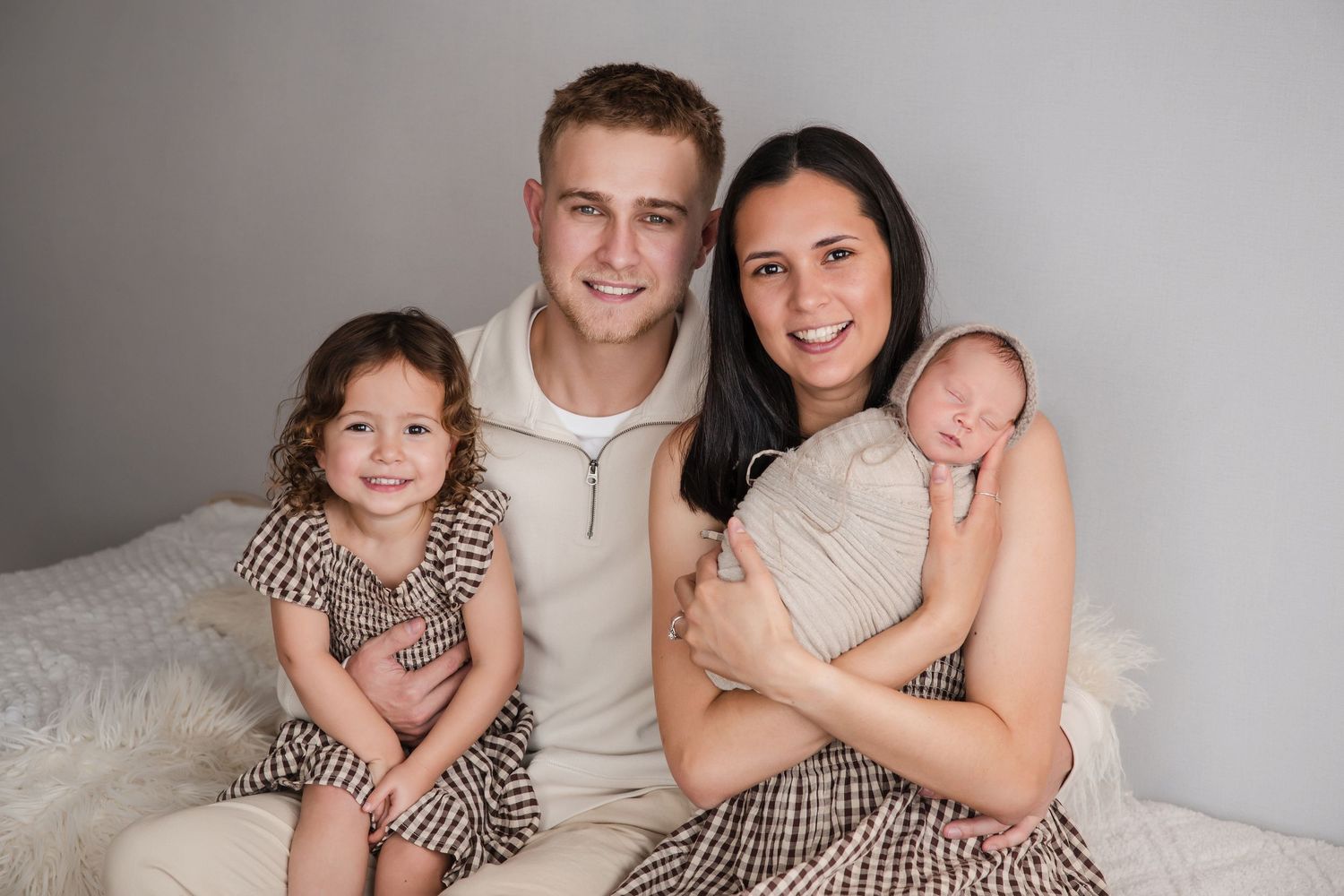 A series of black and white family portrait photos showing loving moments against a light background.