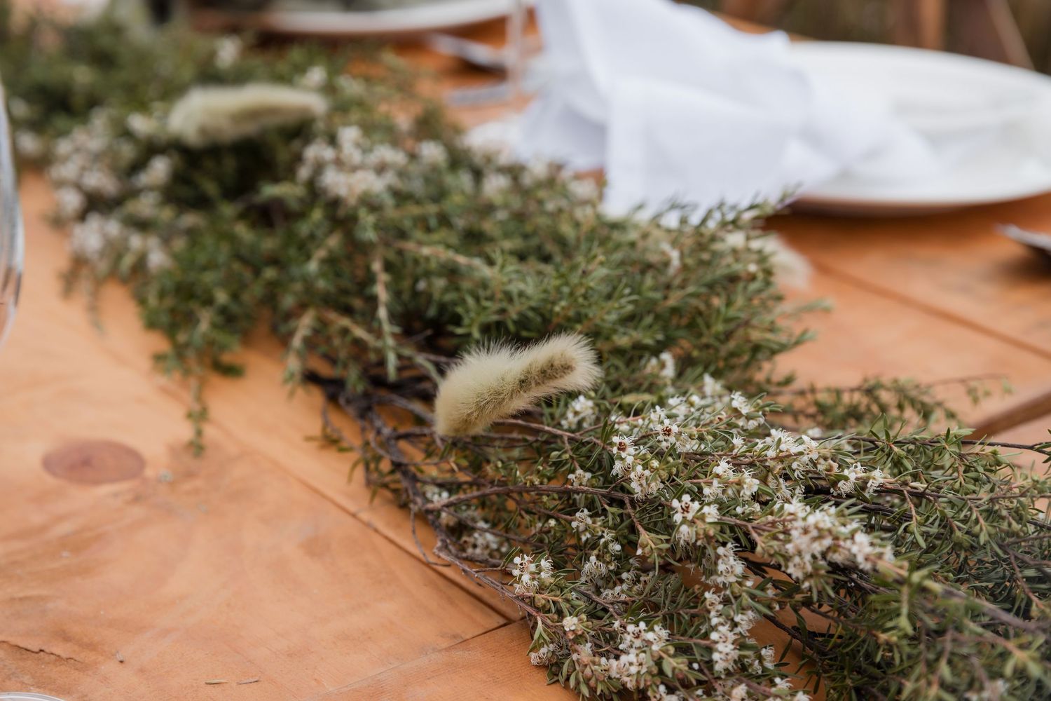 Dried thyme sprigs scattered on a wooden cutting board or table surface.
