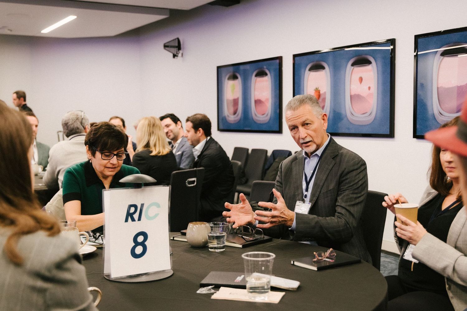People in a conference room looking at mobile devices during a business meeting.