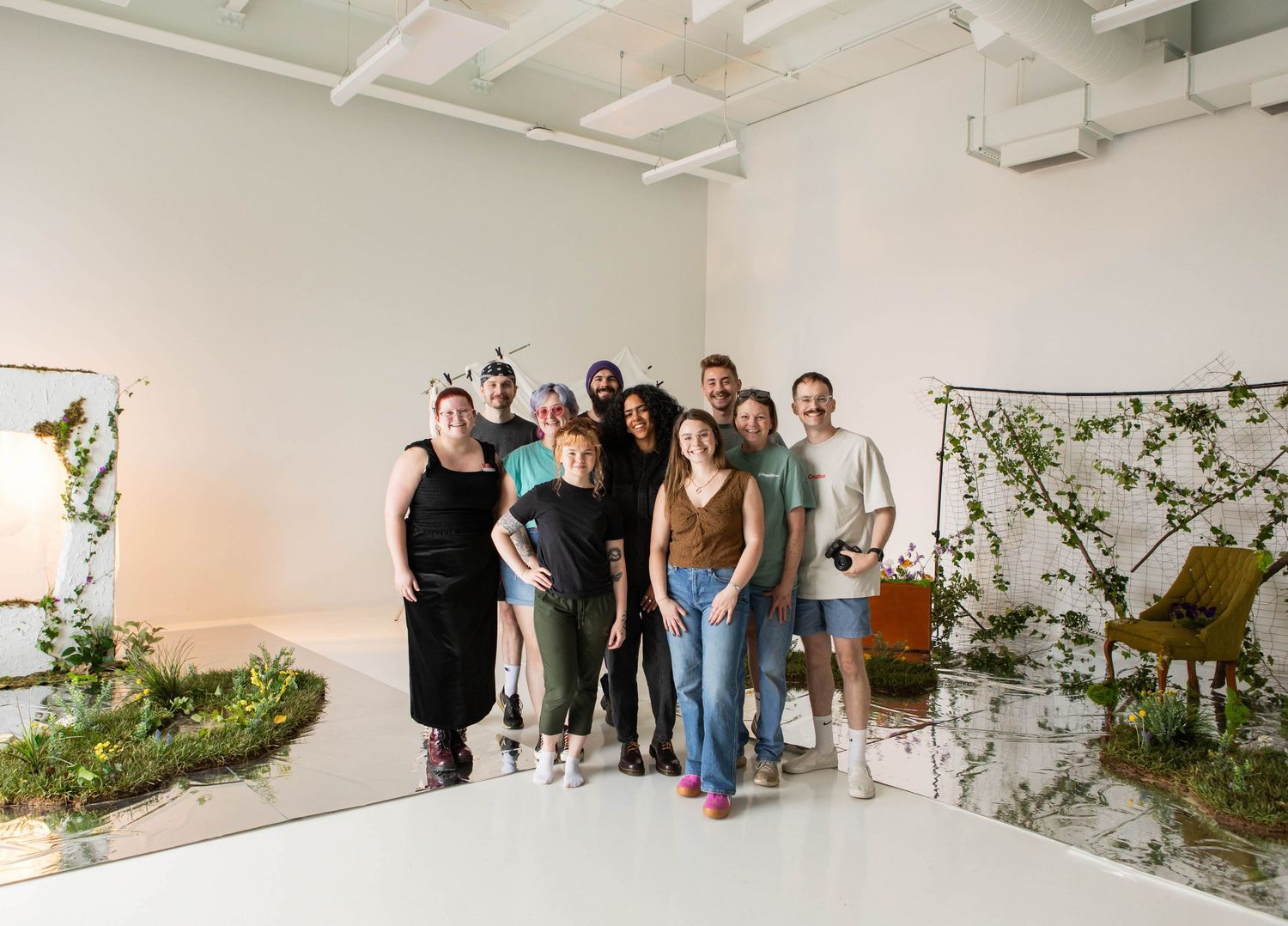 Modern photography studio interior with white walls and artistic nature installations.