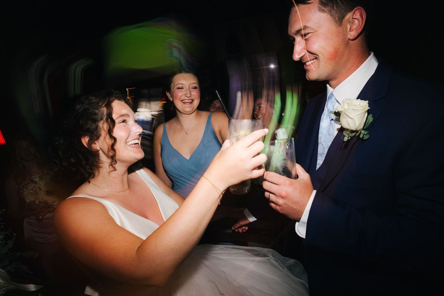 Couple shares a romantic dance moment at their wedding reception in dimly lit ballroom.