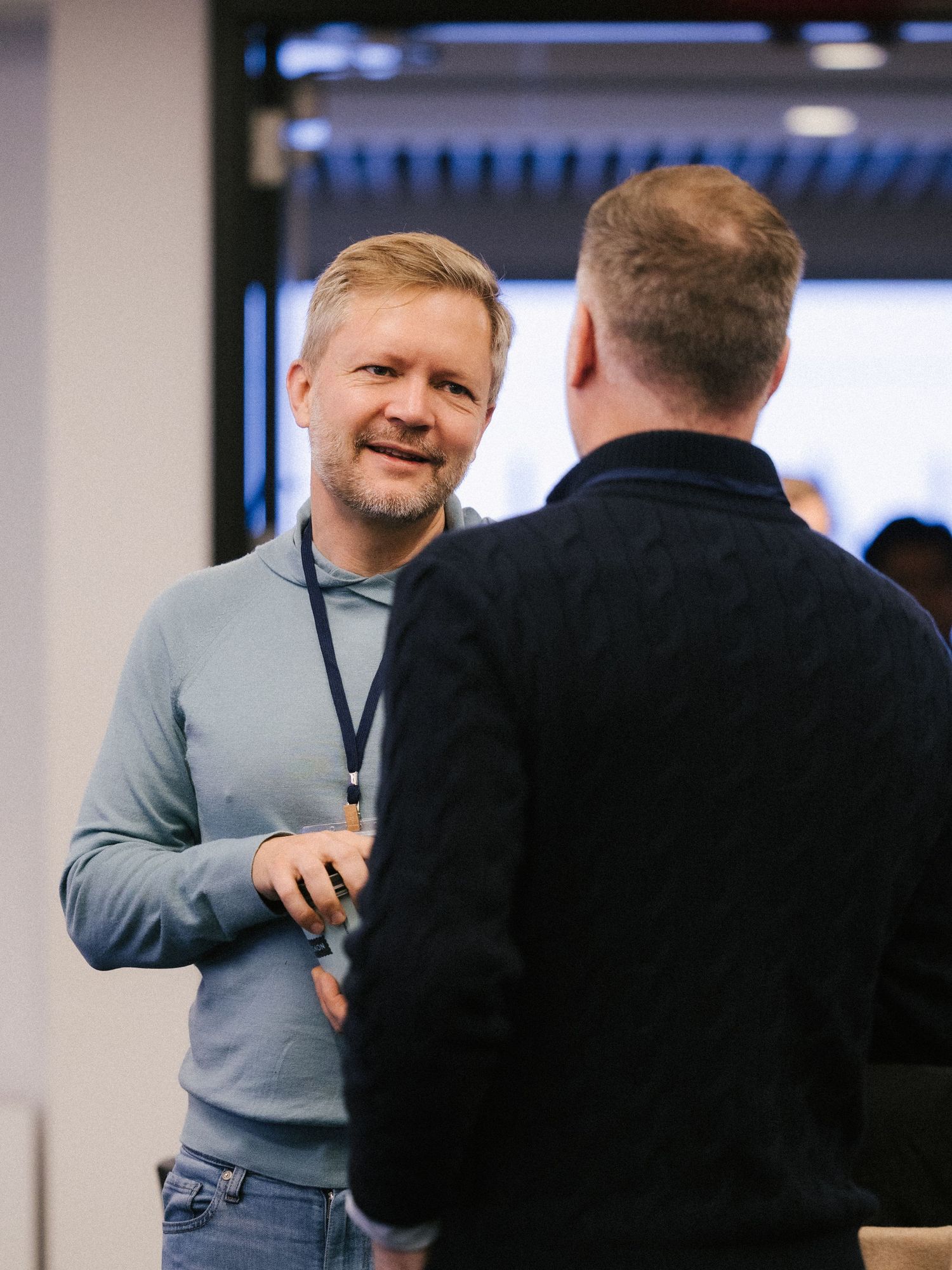 Three connected images show two people having an animated conversation in an office or conference room setting.