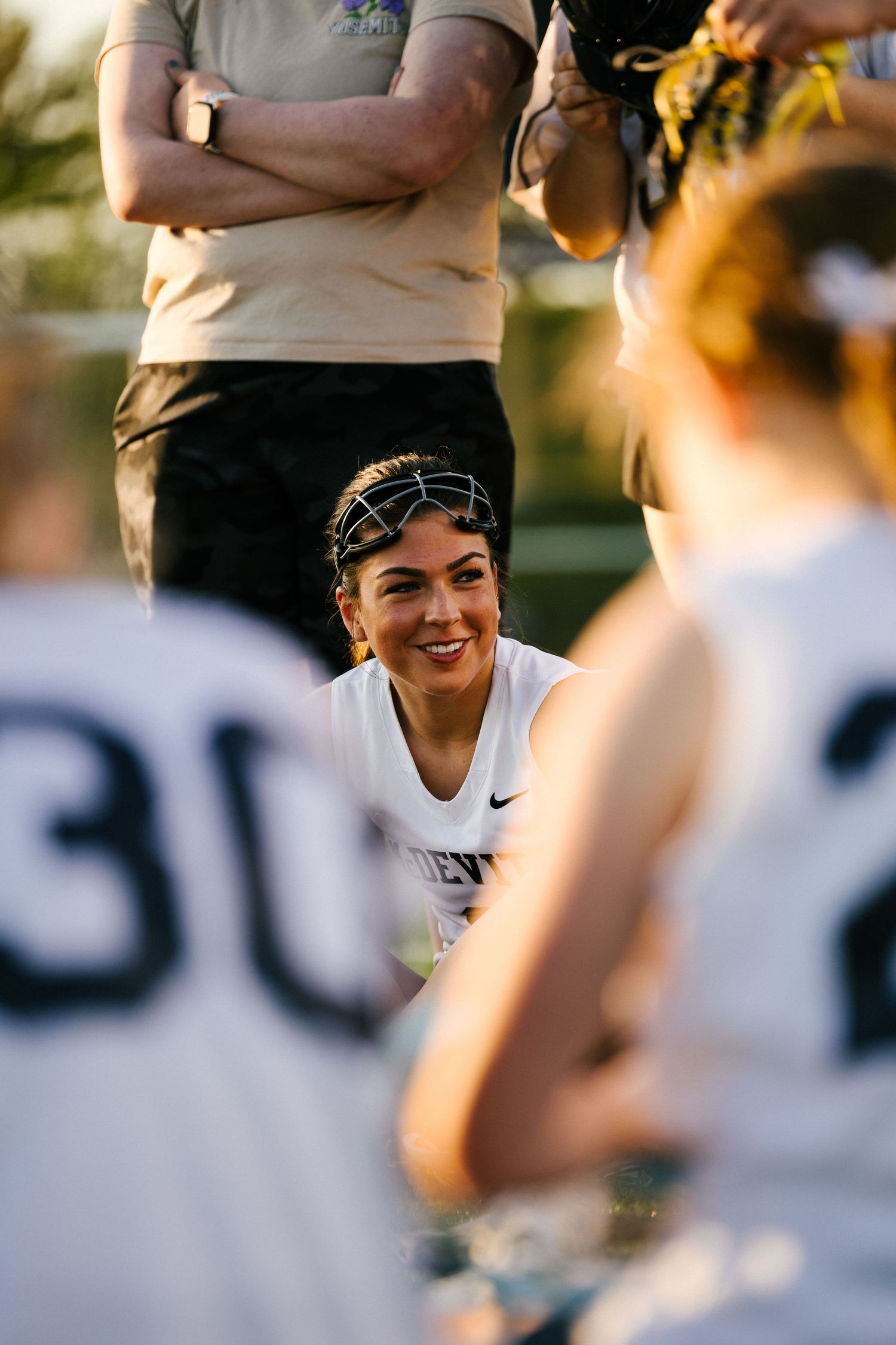 Baseball players share smiles and camaraderie during a sunny outdoor practice session.
