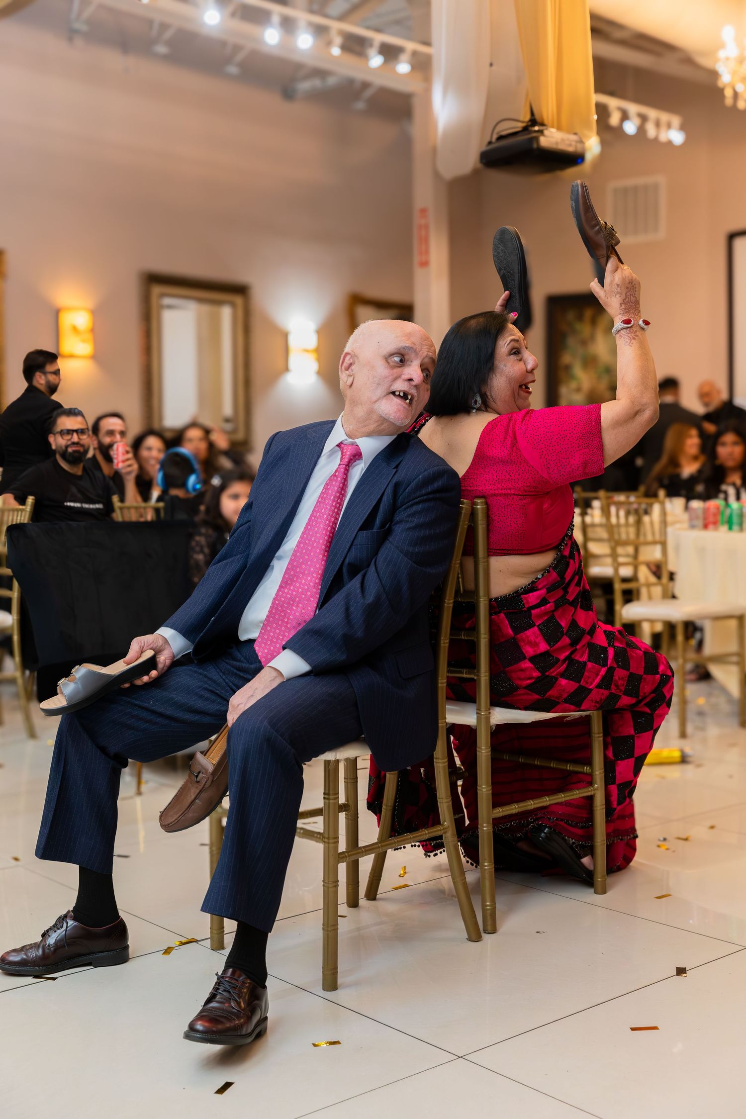 A celebratory moment at a wedding reception with guests playing the shoe game.