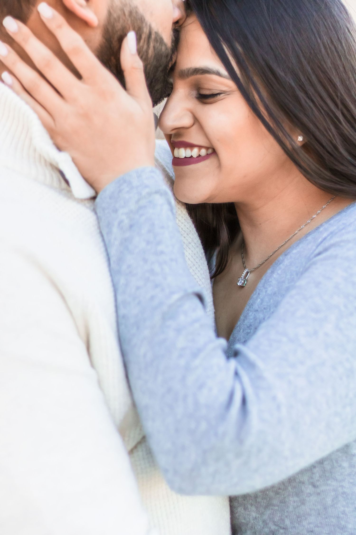 A romantic close-up moment showing affection between a couple wearing soft blue and white clothing.