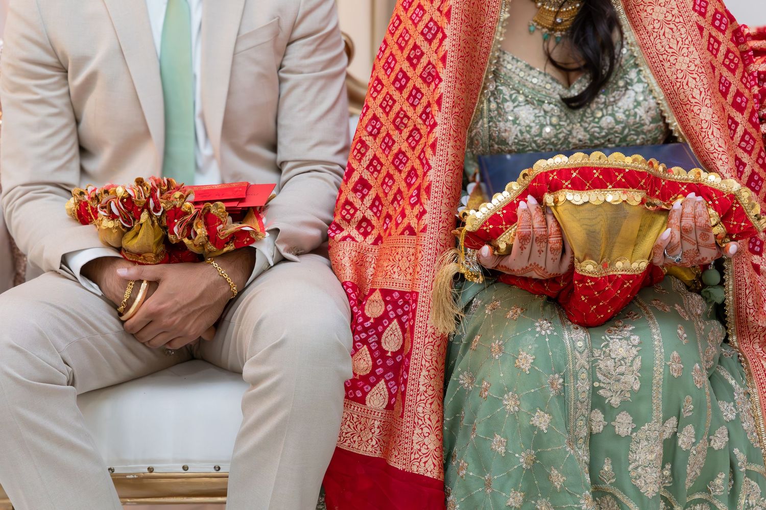 Traditional wedding attire featuring sage suit and mint lehenga with red dupatta details.
