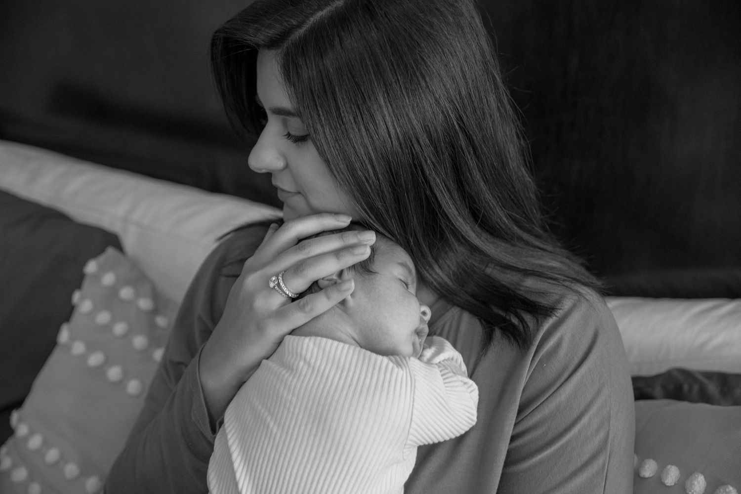 A tender black and white portrait showing an intimate moment with an infant.