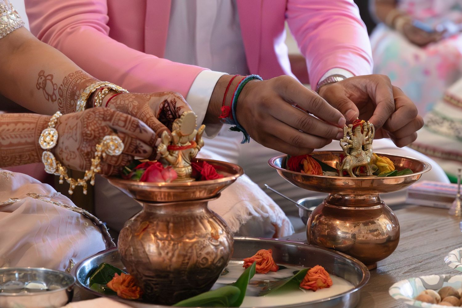 Traditional copper serving pots and bowls filled with Indian cuisine dishes arranged on a wooden dining table.