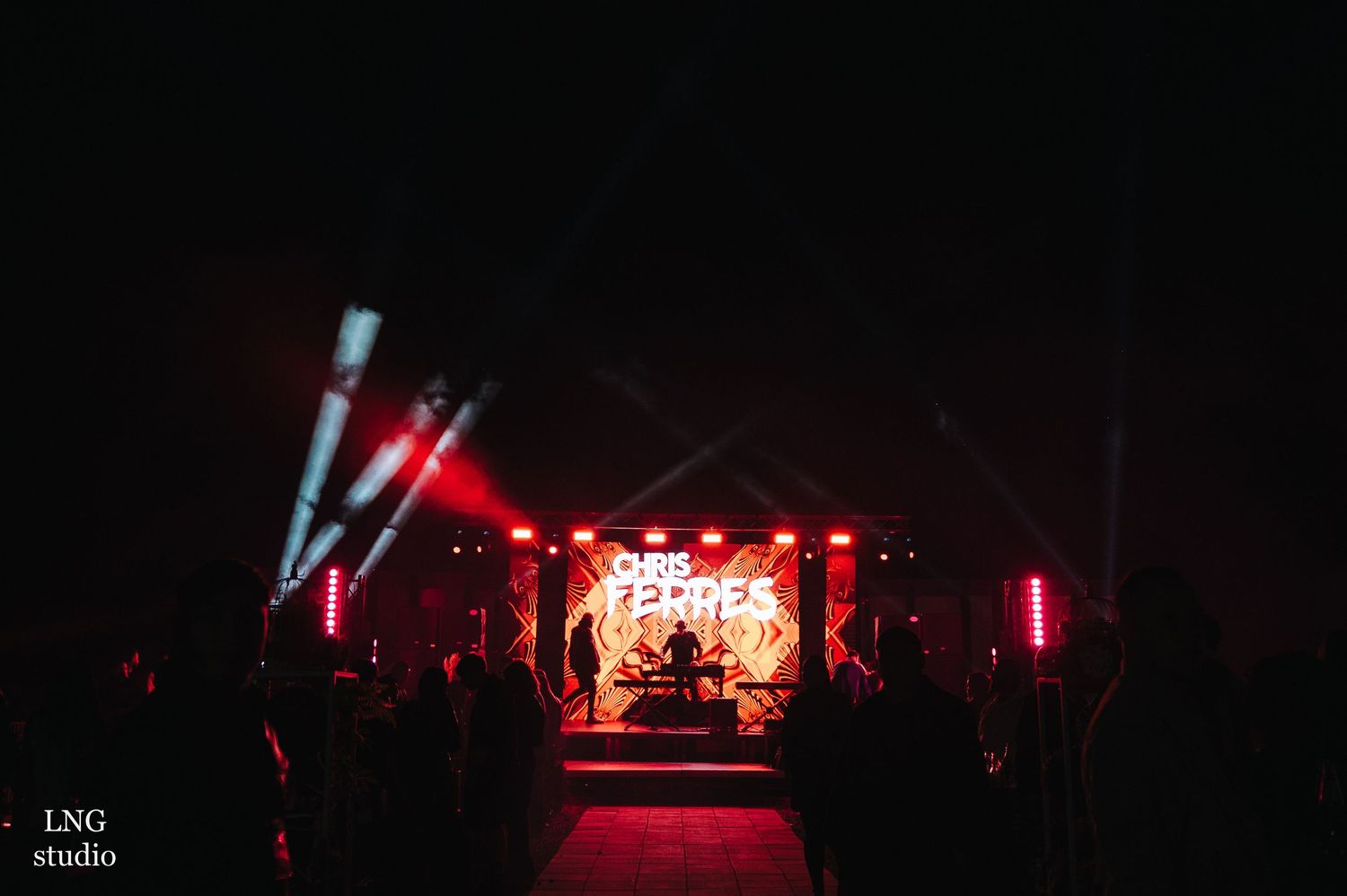 Concert stage lit with red lights and fog creating atmospheric ambiance.