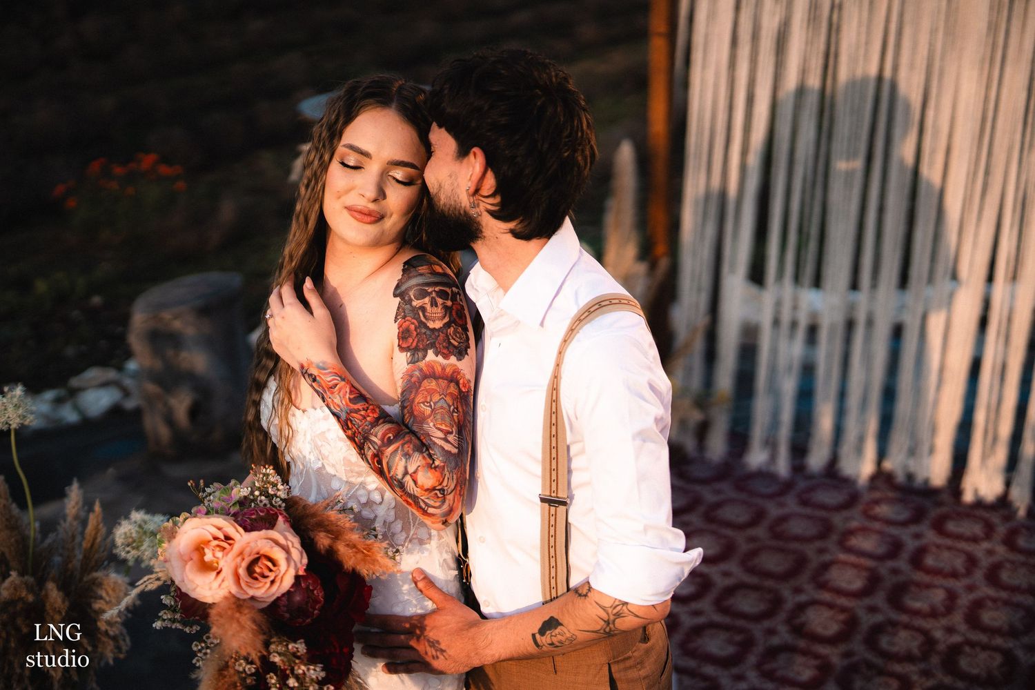 A romantic couple shares an intimate moment in warm evening lighting while sitting together outdoors.