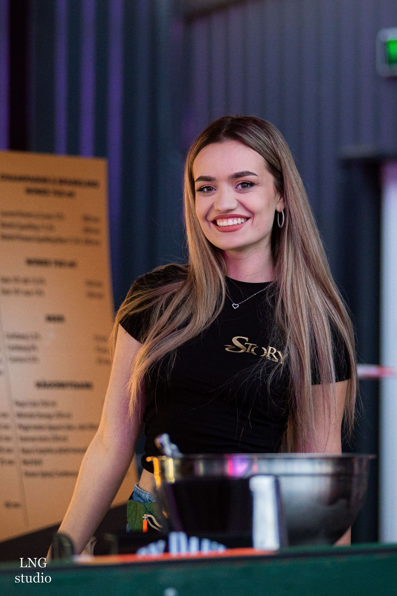 Bar staff in black uniforms working behind a stylishly lit counter during service.