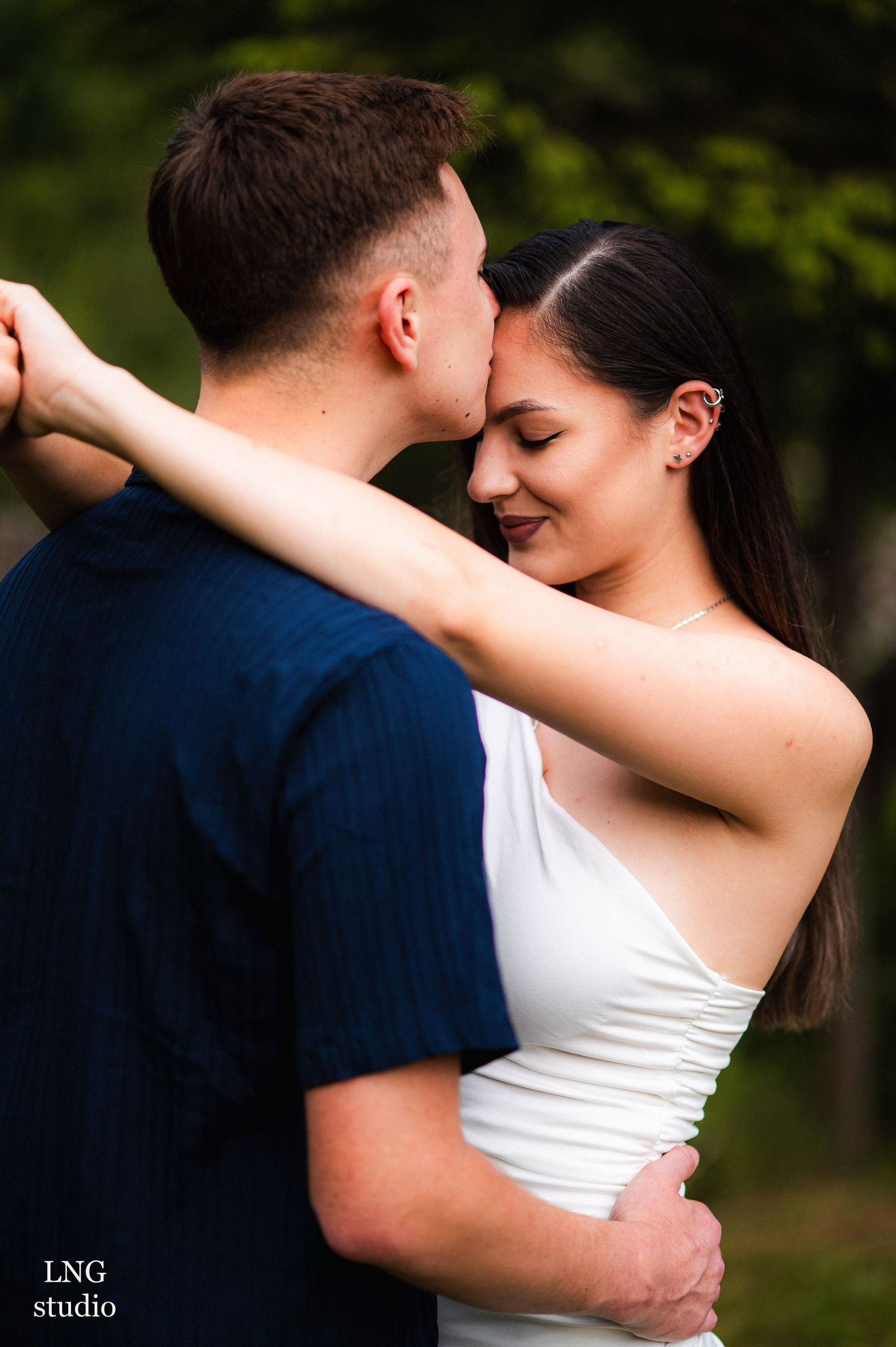 Intimate embraces captured in natural outdoor setting with soft lighting.