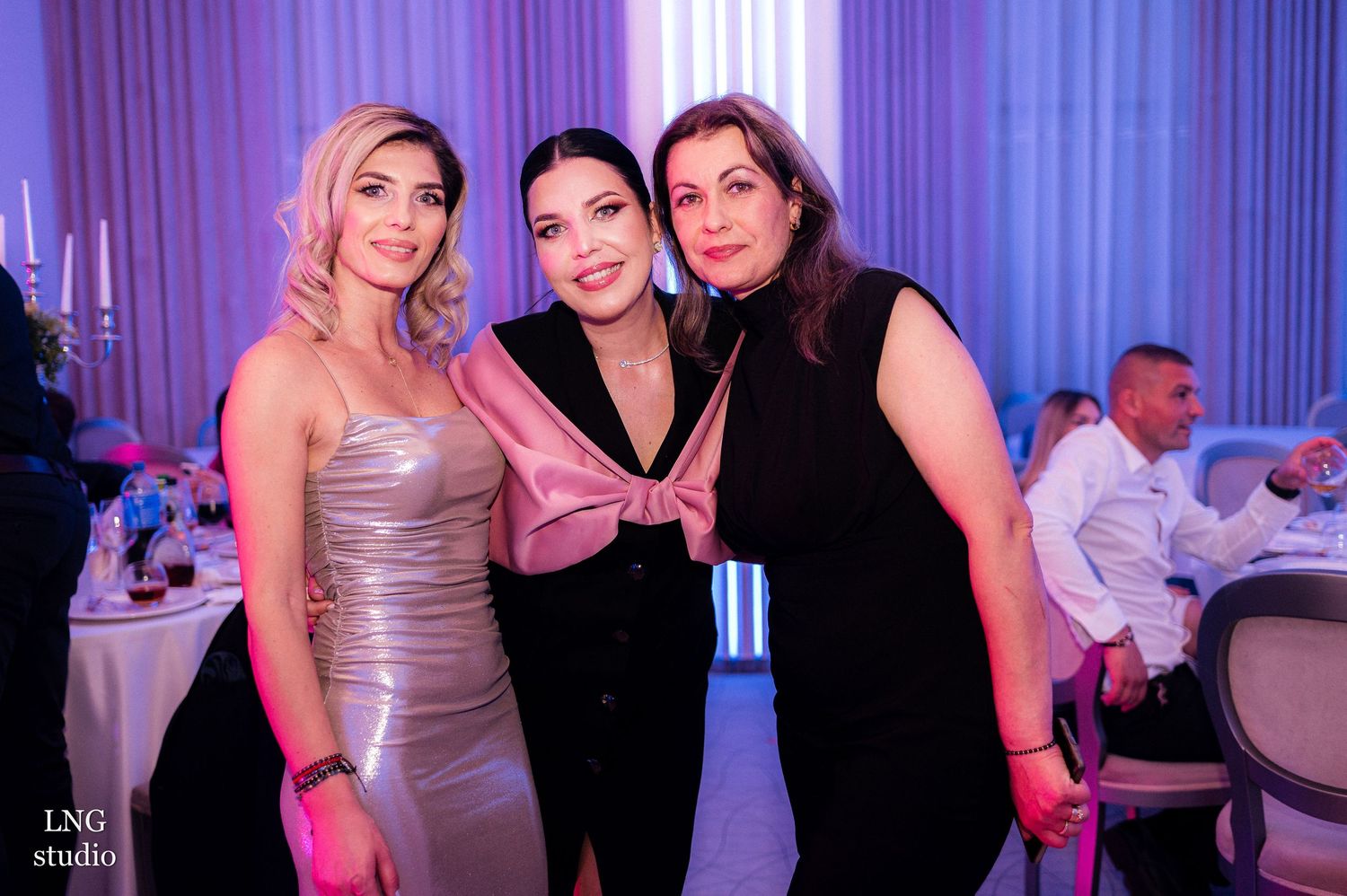 Group celebrating at an event with blue and purple mood lighting.