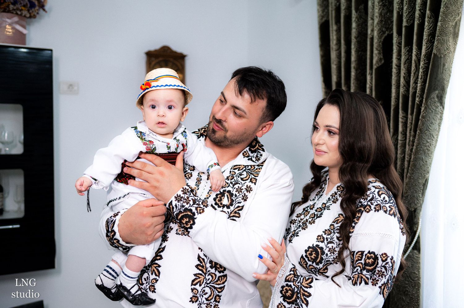 Family in matching white vyshyvanka shirts with intricate brown embroidery patterns.