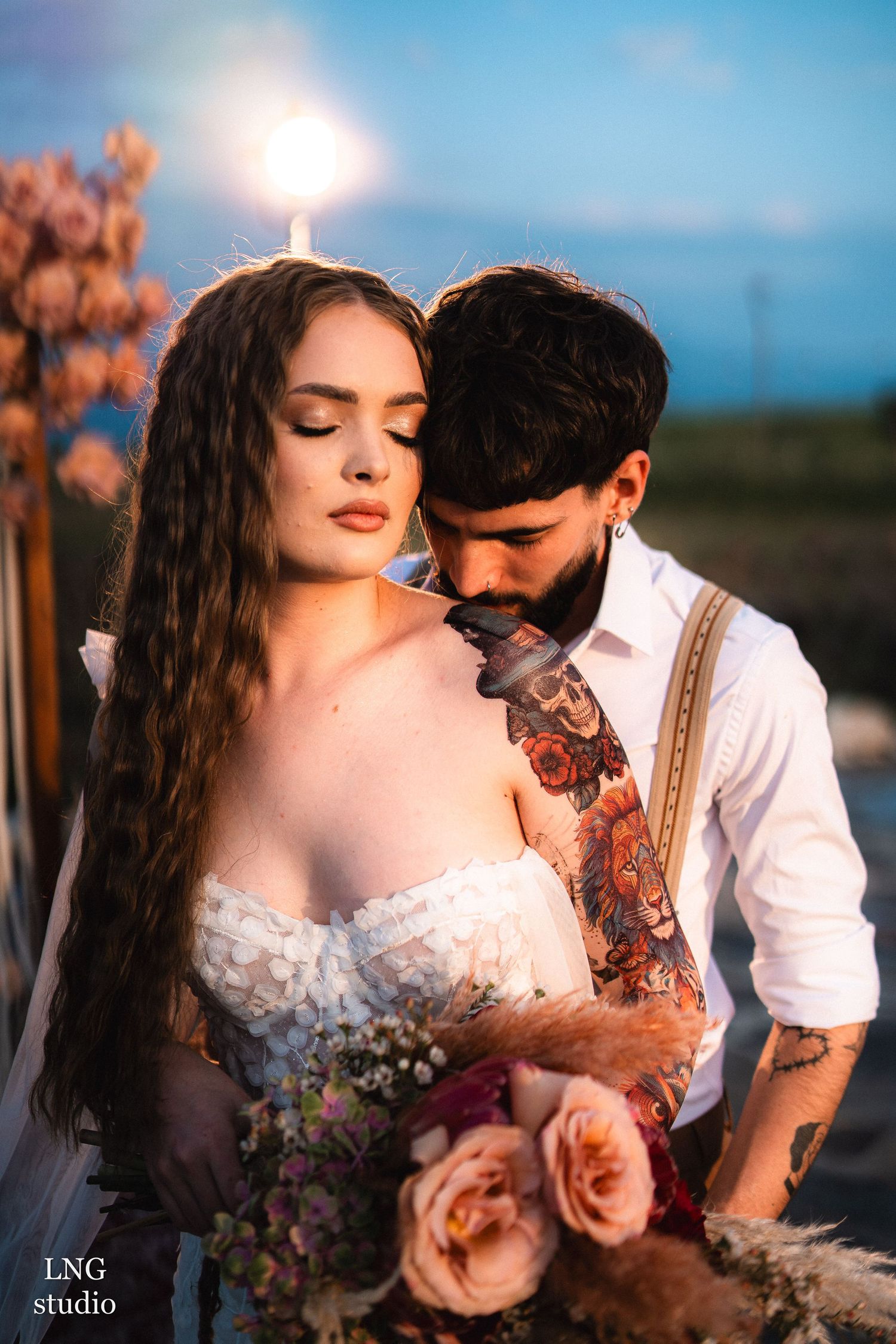 Romantic sunset photoshoot capturing a couple sharing intimate moments in golden light while wearing rural-inspired attire.