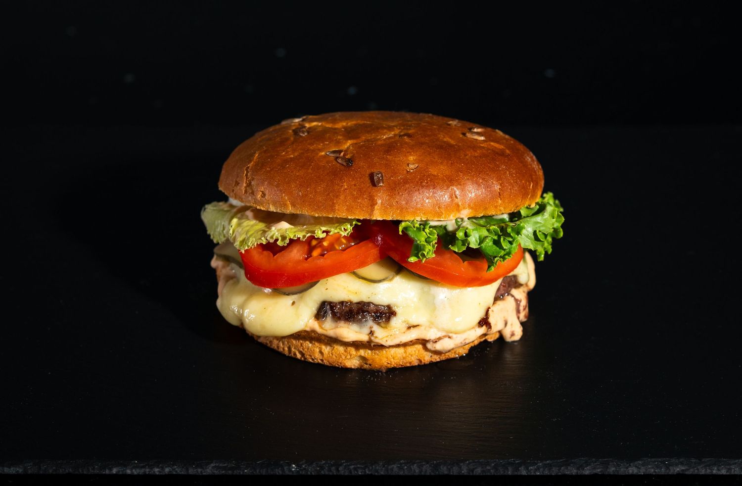 A juicy cheeseburger with fresh lettuce, tomato and melted cheese on a seeded bun.
