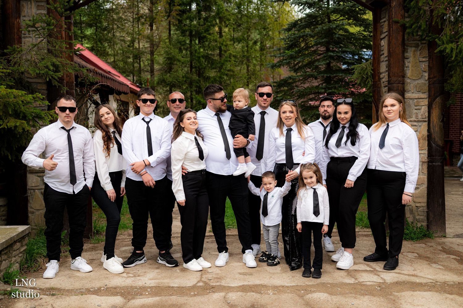 Wedding party group photo with groomsmen and bridesmaids in black and white attire.