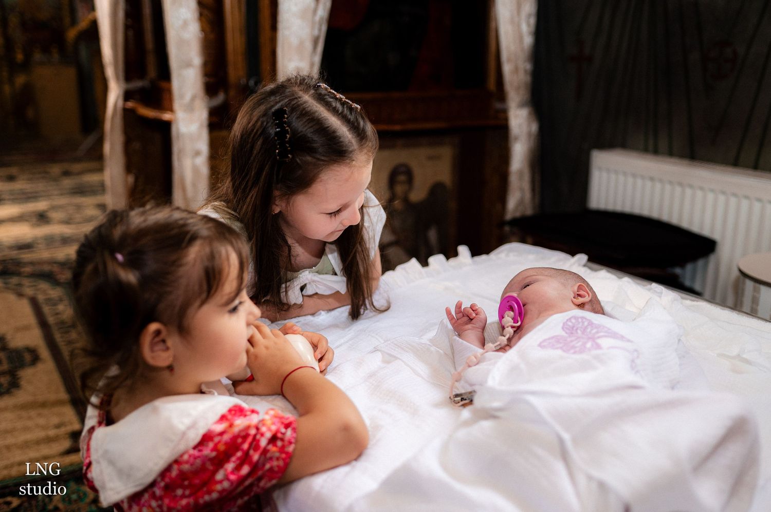 Children gathered around a table during a religious ceremony.