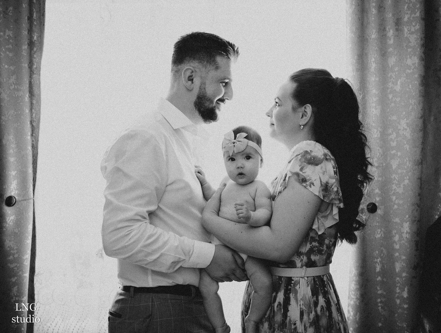 A black and white portrait of a family sharing a tender moment together.