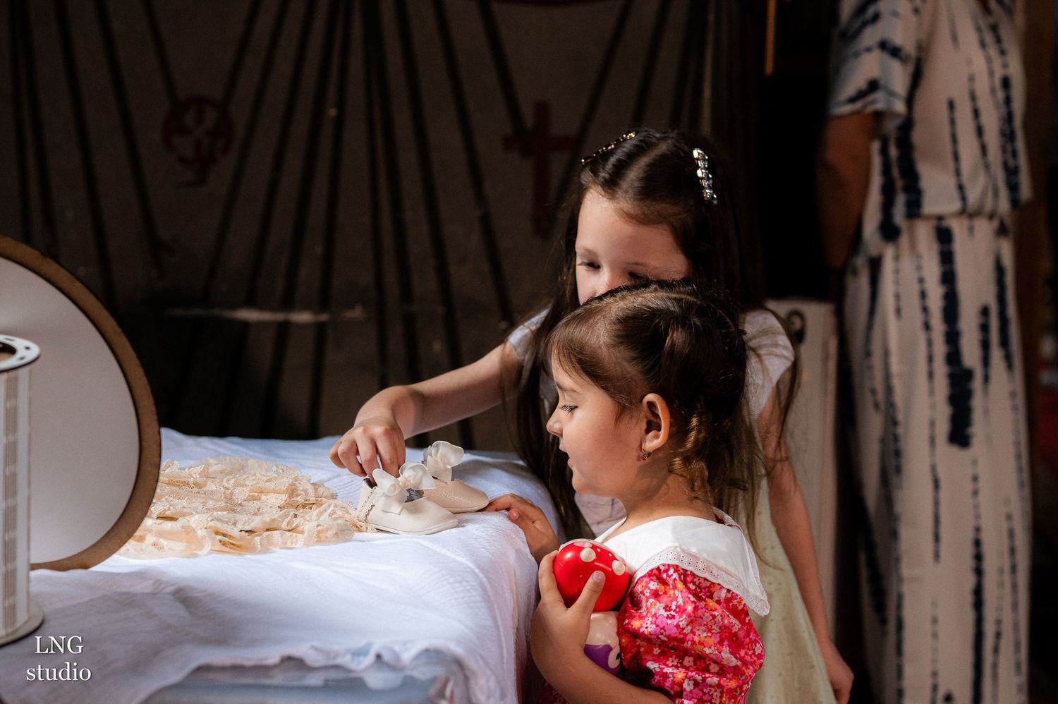 Two people preparing items on a white tablecloth for a religious ceremony.