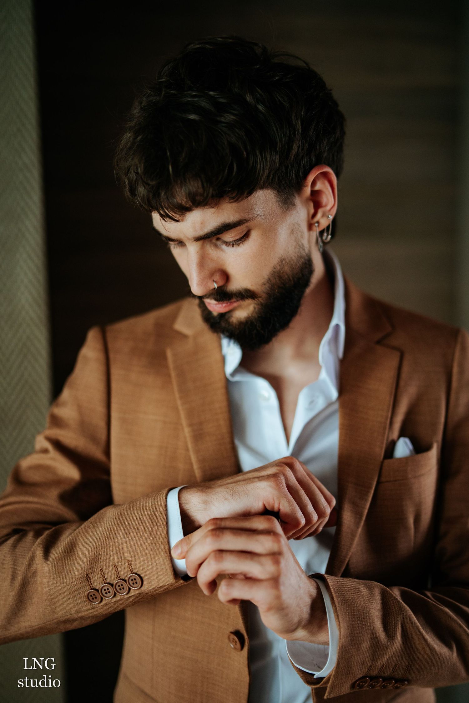 Close-up sequence showing a person wearing a brown suit jacket adjusting their collar in moody lighting and atmosphere.